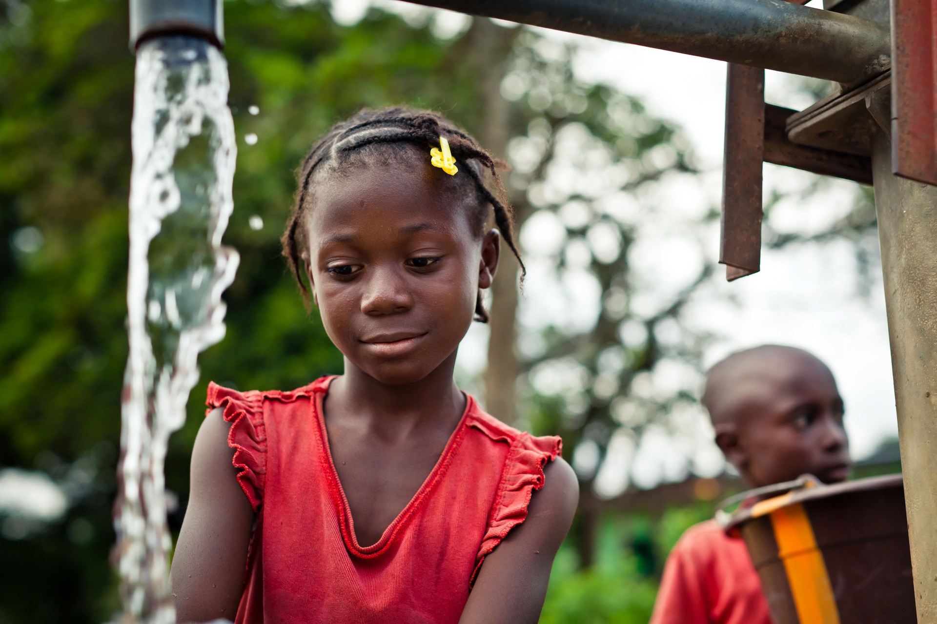 African Girl By Water Pump